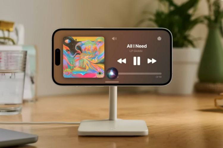 Dengan StandBy Mode di iOS 17, pengguna bisa menyalakan musik secara handsfree dengan memberikan perintah ke Siri. Layar akan menampilkan cover album/lagu lengkap dengan judul lagu, durasi lagu, dan ikon pause, previous, dan next.