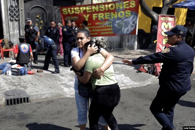 Seorang perempuan menenangkan temannya setelah seorang kerabat ditembak orang tak dikenal di luar bengkel di Mexico City, Meksiko, 12 Februari 2021.