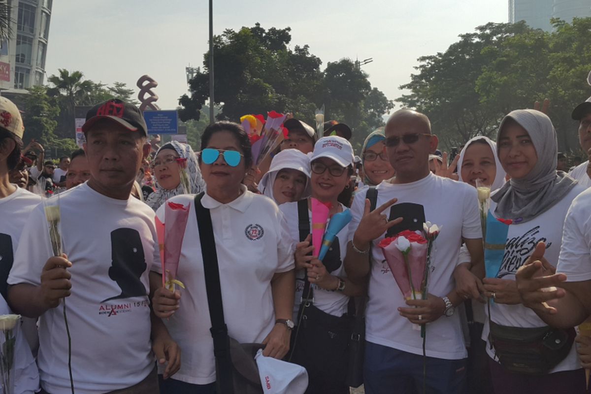 Relawan Rumah Djoeang membagikan bunga sebagai gelaran syukuran kemenangan pasangan Gubernur dan Wakil Gubernur DKI Jakarta terpilih Anies Baswedan-Sandiaga Uno di area car free day, Jakarta Pusat, Minggu (7/5/2017).