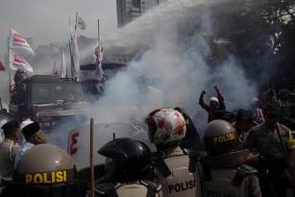 Polisi menembakkan gas air mata dan water cannon untuk membubarkan massa pendukung Prabowo-Hatta yang berusaha menerobos masuk menuju Gedung Mahkamah Konsistusi (MK) di Jalan Medan Merdeka Barat, Jakarta, Kamis (21/8/2014). Hari ini MK akan memberikan putusan atas kasus perselisihan hasil pemilihan umum (PHPU) presiden dan wakil presiden 2014. 
