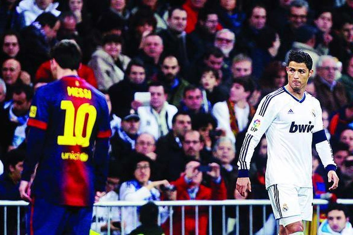 Bintang Barcelona, Lionel Messi (kiri), berpapasan dengan seterunya, bintang Real Madrid, Cristiano Ronaldo, dalam semifinal laga pertama Copa del Rey di Stadion Santiago Bernabeu, Madrid, Rabu (30/1). Kedua tim bermain imbang 1-1.