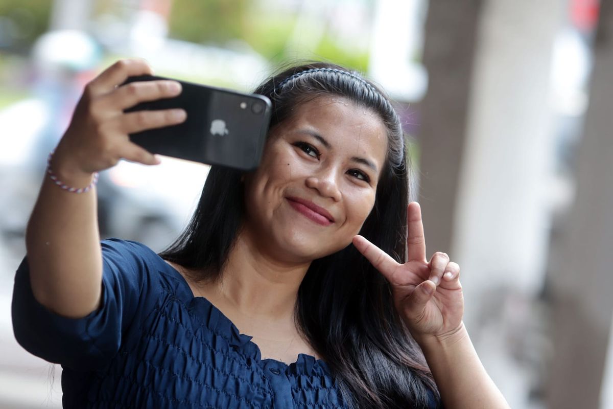 Putri seorang warga Surabaya saat selfie menggunakan iphone.