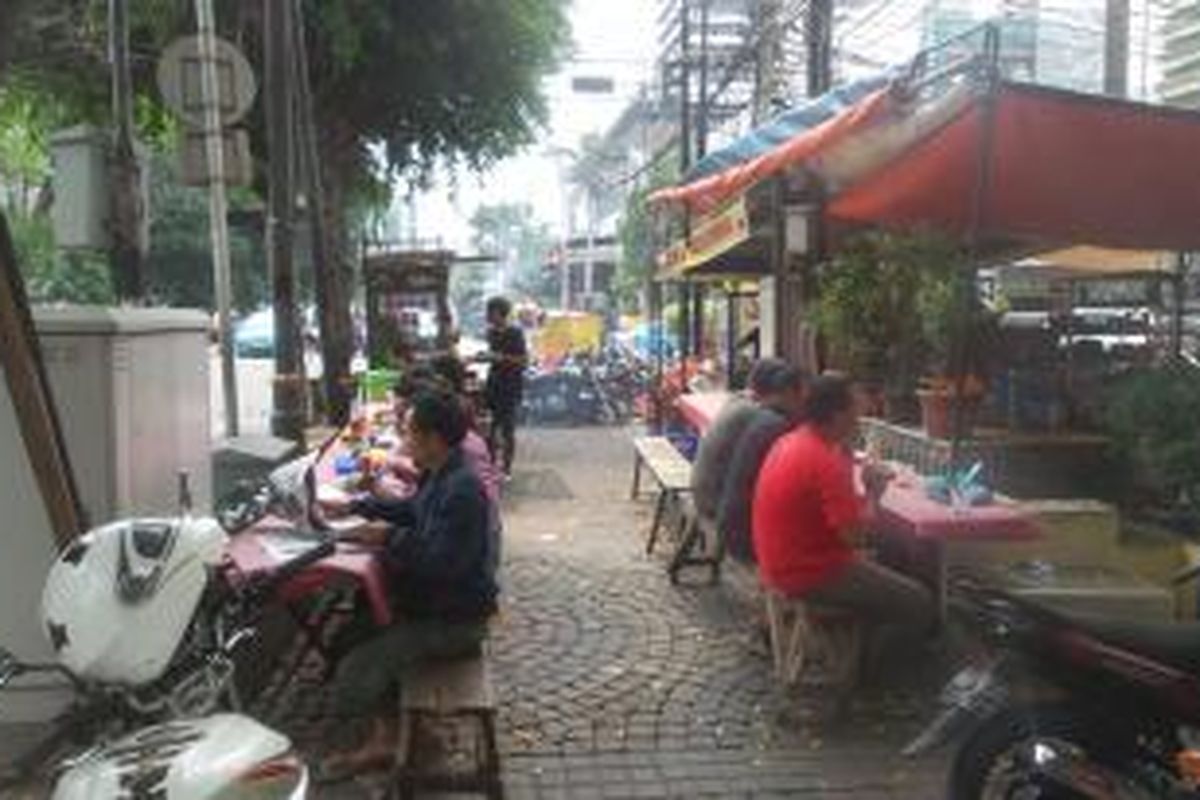 Sejumlah pekerja kantoran yang sedang menyantap makan siang di parkiran Jalan Wahid Hasyim, Jakarta Pusat, Jumat (15/1/2016) siang. Situasi di jalan yang tak jauh dari kawasan Sarinah itu masih normal. Meskipun pada Kamis kemarin sempat ada aksi peledakan bom di Sarinah.