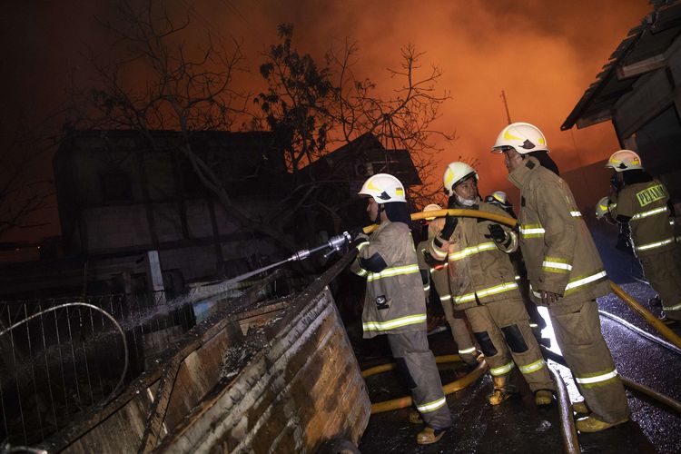 Sejumlah petugas berusaha memadamkan api yang membakar rumah warga imbas kebakaran Depo Pertamina Plumpang,kawasan Jalan Koramil, Rawa Badak Selatan, Koja, Jakarta Utara, Jumat (3/3/2023).