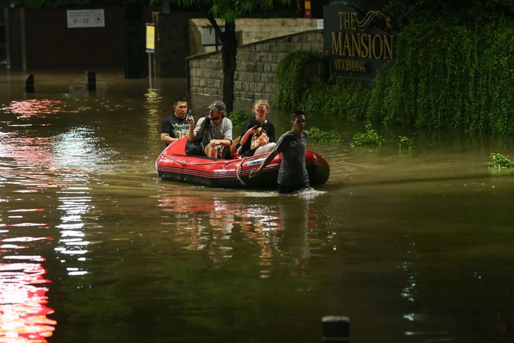 Warga melintasi banjir yang mengenang kawasan Kemang, Jakarta Selatan, Kamis (6/10/2022) malam. Hujan deras yang mengguyur wilayah Jakarta siang menyebabkan Jalan Kemang Raya, Jakarta Selatan, terendam banjir.