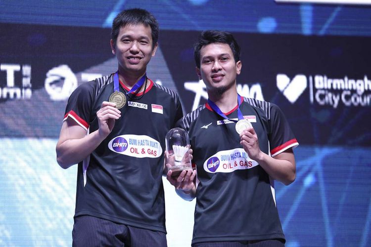 Pebulu tangkis ganda putra Indonesia Hendra Setiawan (kiri) dan Mohammad Ahsan menunjukan medali usai memenangi pertandingan melawan ganda putra Malaysia Aaron Chia dan Soh Wooi Yik pada babak final All England 2019 di Arena Brimingham, Inggris, Minggu (8/3/2019). Ganda Putra Hendra/Ahsan menjuarai All England 2019 setelah mengalahkan Aaron Chia/Soh Wooi Yik dengan skor 11-21, 21-14 dan 21-12