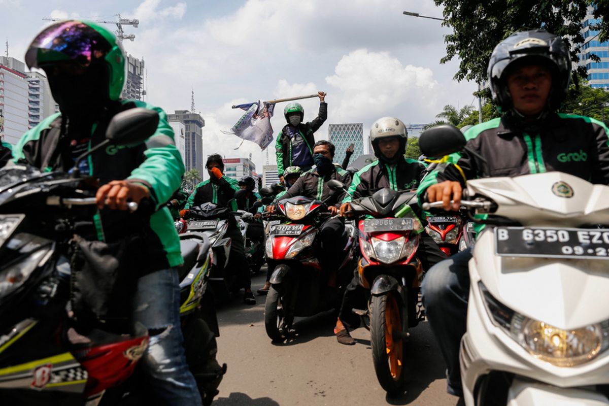 Pengemudi ojek online melakukan aksi unjuk rasa di depan Istana Negara, Jakarta Pusat, Selasa (27/3). Massa dari pengemudi ojek online menuntut pemerintah membantu untuk berdiskusi dengan perusahaan transportasi online agar merasionalkan tarif.