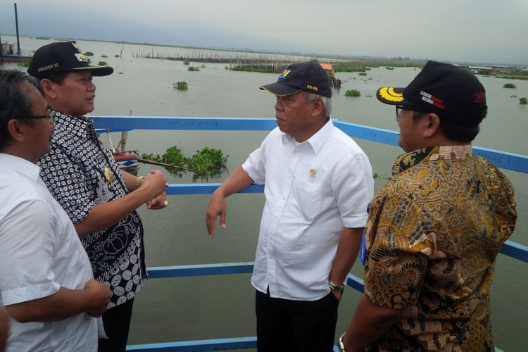 Menteri Pekerjaan Umum dan Perumahan Rakyat (PUPR), Basuki Hadimuljono berbincang dengan Bupati Semarang disela meninjau proses pembersihan enceng gondok Rawapening di dermaga Sumurup, desa Asinan, Bawen, Kabupaten Semarang, Jumat (7/4/2017).