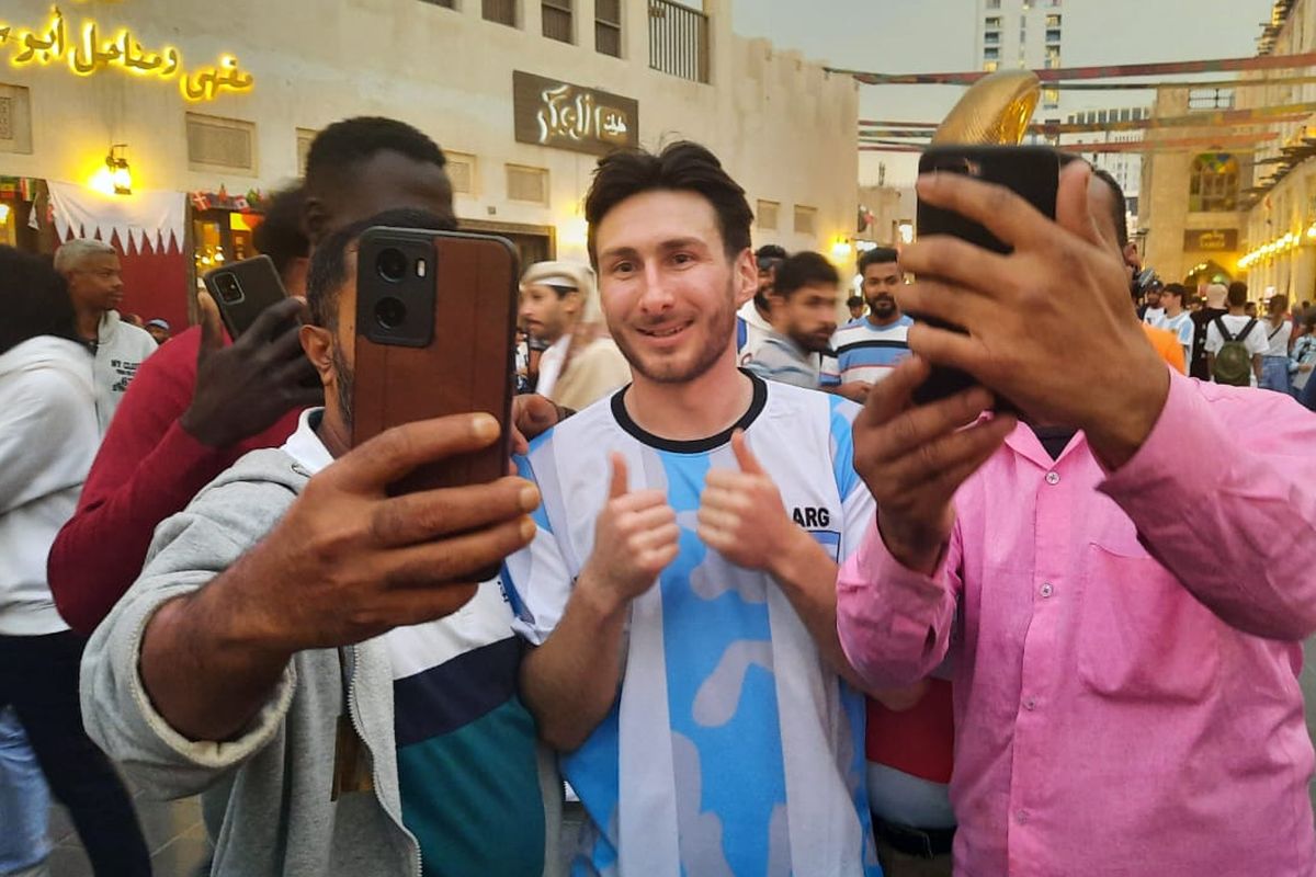 Seorang pria asal Inggris, Mathew Webb, menjadi sasaran foto di pasar tradisional Qatar, Souq Waqif, Senin (19/12/2022) karen kemiripannya dengan bintang timnas Argentina, Lionel Messi. 