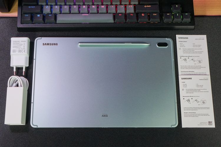 Aksesori-aksesori pelengkap di kemasan Galaxy Tab S7 FE 5G, mencakup charger 15 watt, kabel USB A ke USB C, SIM card ejector tool, stylus S Pen, serta booklet panduan singkat dan garansi