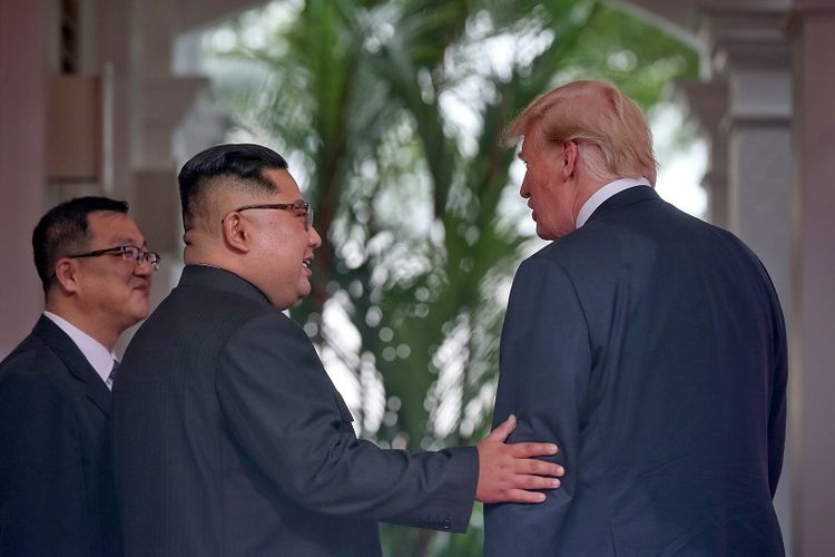 Pemimpin Korea Utara Kim Jong Un berbincang dengan Presiden AS Donald Trump (R) saat keduanya bertemu di Hotel Capella, Pulau Sentosa, Singapura, Selasa (12/6/2018). 