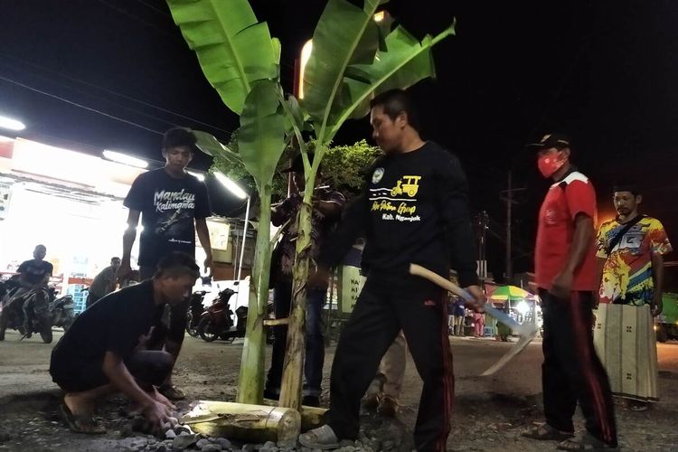 Warga Desa Talang Nganjuk menanam pohon pisang di Jalan Raya Talang Rejoso, Selasa (20/3/2021) malam. Aksi ini sebagai bentuk protes warga karena jalan tersebut rusak parah namun tak kunjung diperbaiki.