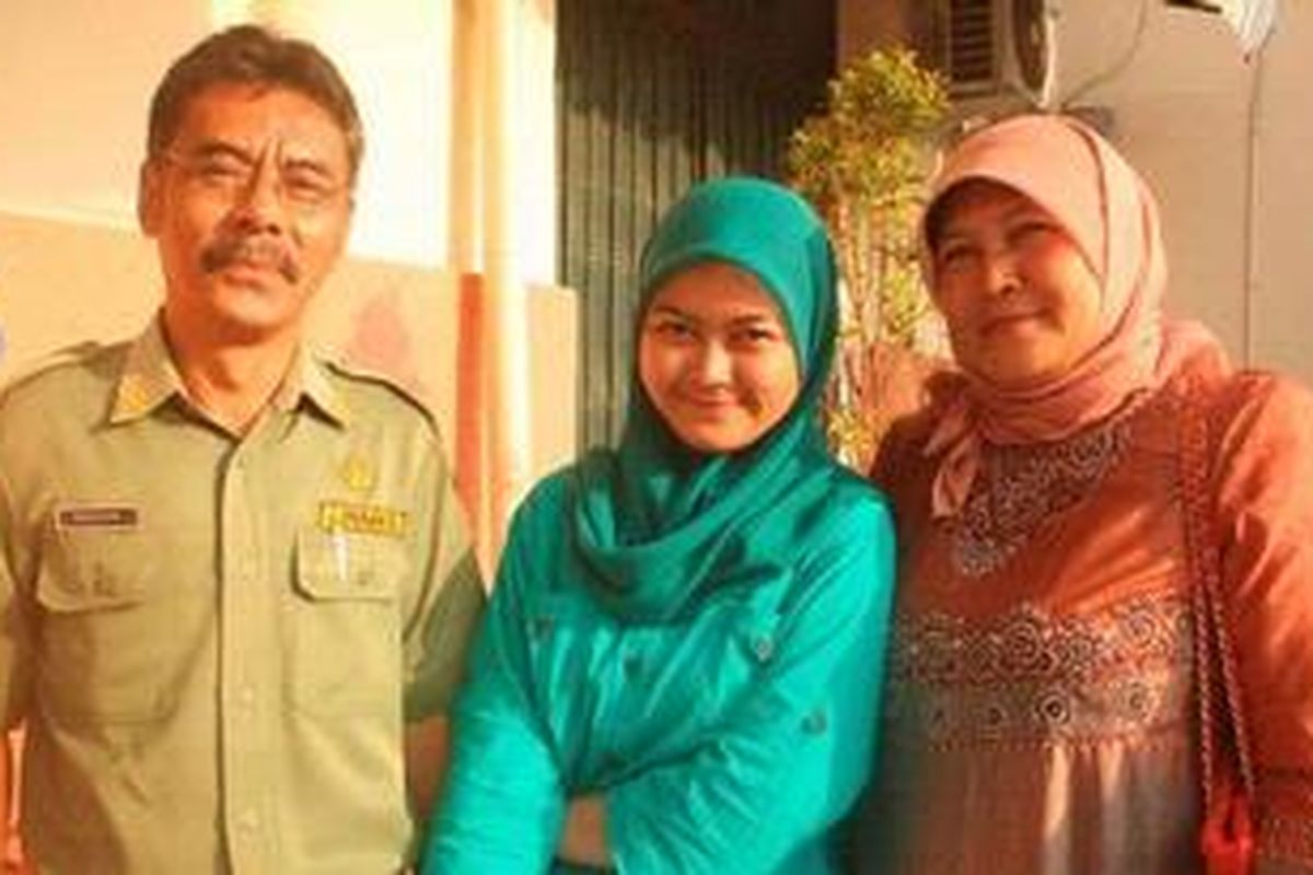Triawati Octavia (18) diapit oleh ayahnya Syahrul Arifin (54) dan ibunya Uhintawati (52), Senin (28/5/2012), saat ditemui di Cirebon, Jawa Barat. Triawati Octavia, siswa SMUN 2 Kuningan meraih nilai ujian nasional tertinggi tingkat SLTA se-Indonesia, yakni 58,60 dari enam mata pelajaran yang diujikan. Prestasi ini membuatnya ditawari beasiswa dari sejumlah instansi. 