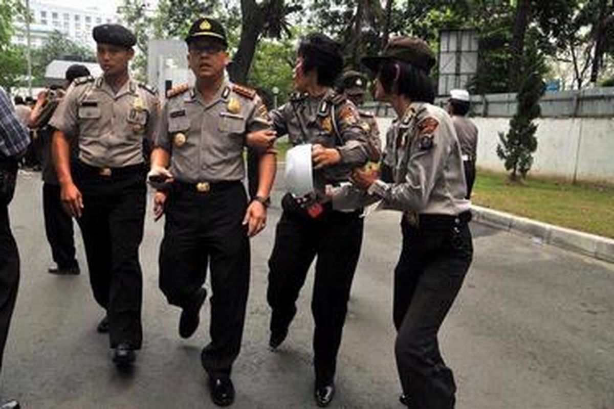 Kapolresta Medan Monang Situmorang (tengah) digandeng seorang polwan yang mencoba mengamankannya dari lemparan batu saat unjuk rasa ricuh di halama gedung DPRD SUmatera Utara, Medan, Rabu (21/32012). Unjuk rasa berakhir ricuh karena mahasiswa dihalanagi polisi saat hendak memasuki halaman gedung DPRD Sumut.