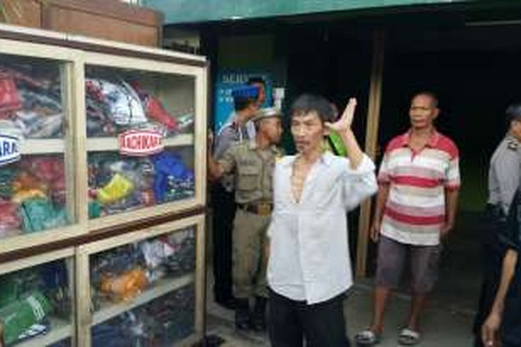 Pemilik toko, Silly Suryono mengenakan baju putih nampak emosi setelah tim eksekusi Pengadilan Negeri Ponorogo mengeluarkan barang-barangnya dari toko di Jalan Gatot Koco,Kelurahan Brotonegaran, Kota Ponorogo, Selasa ( 15 / 11 / 2016) 