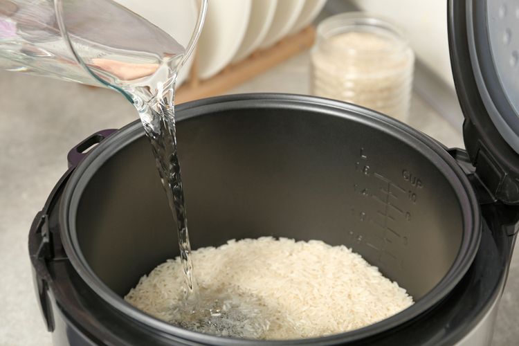 Ilustrasi menuang air untuk memasak beras di rice cooker atau penanak nasi. Memasak nasi di rice cooker tak hanya mudah, tetapi juga cepat. 