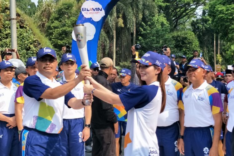 Presenter Sandra Olga menyerahkan obor Asian Games kepada Wali Kota Jakarta Selatan Marullah Matali di pintu masuk Taman Margasatwa Ragunan, Jakarta Selatan, Rabu (15/8/2018).