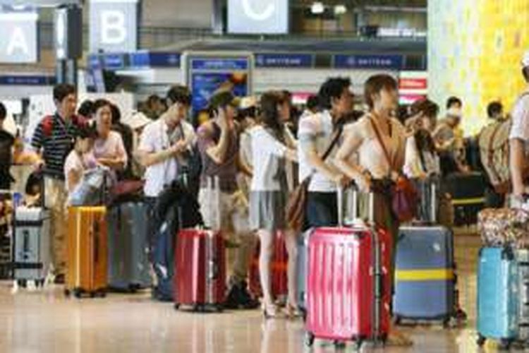 Antrean turis China di sebuah bandara.