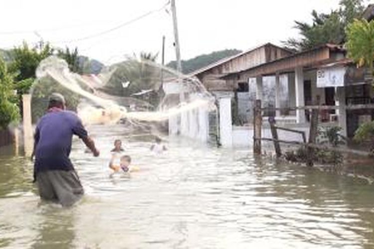 Warga Desa Garut Kecamatan Darul Imarah, Kabupaten Aceh Besar, bermain air genangan banjir, untuk menghilangkan kejenuhan karena banjir yang belum surut.