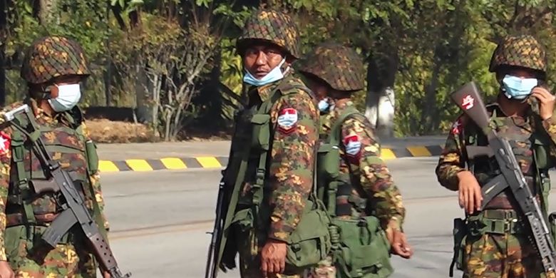 Soldiers stand guard on a street in Naypyidaw on February 1, 2021, after the military detained the country's de facto leader Aung San Suu Kyi and the country's president in a coup. (Photo by STR / AFP)