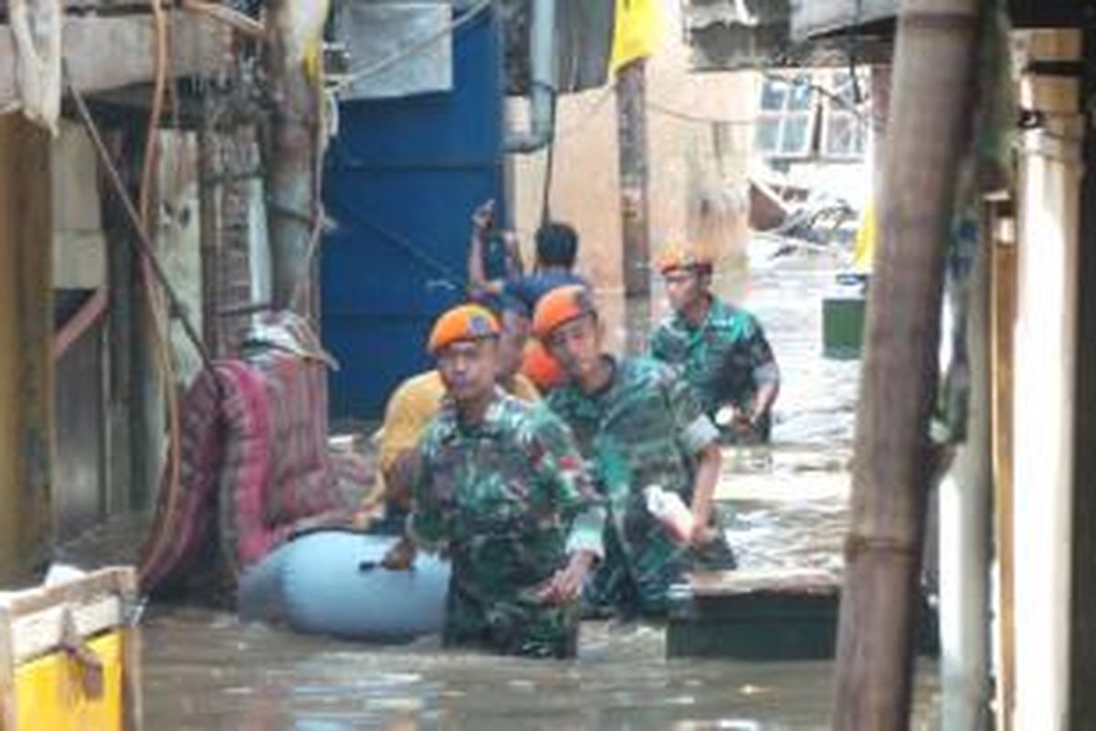 Korps Pasukan Khas TNI AU membantu evakuasi warga korban banjir di Kampung Pulo, Jakarta Timur. Selasa (14/1/2014).