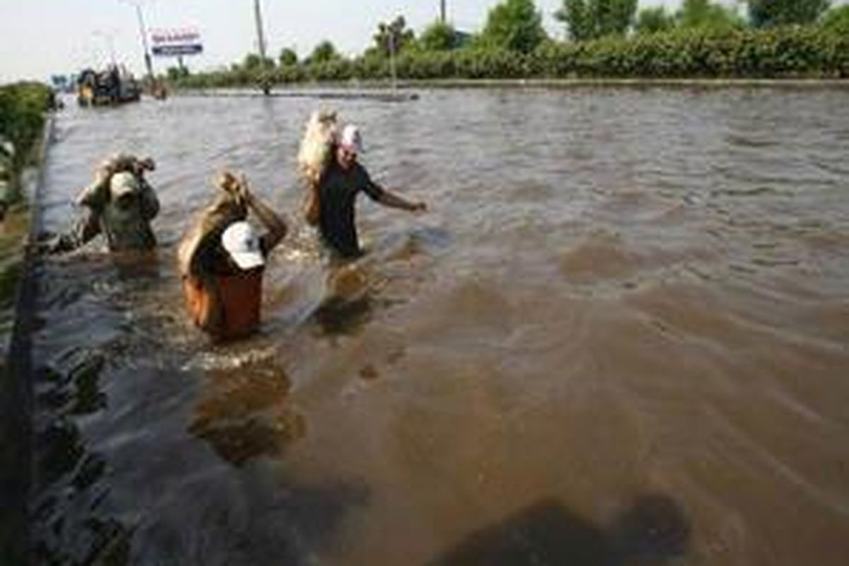 Jalan Tol Bandara Terputus Pekerja membawa karung pasir untuk menambal tanggul yang jebol di samping Jalan tol Sedyatmo Km 26,6, Tangerang, Provinsi Banten, Kamis (8/5). Jalan tol Sedyatmo menuju dan dari bandara Soekarno-Hatta di Km 26 -27 tergenang air hingga satu meter dan menyebabkan kemacetan parah dan terganggunya jadwal penerbangan. 