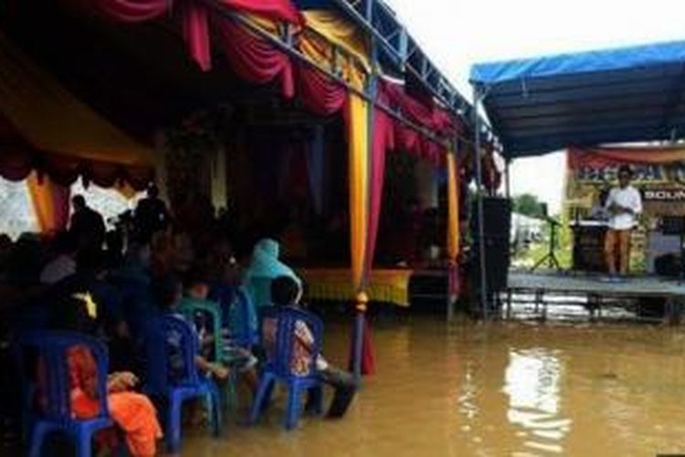 Banjir yang merendam Dusun Kampung Masjid, Desa Santan Tengah, Kecamatan Marangkayu tidak menghalangi pasangan sejoli M Faizal dan Nurjanah mereguk kebahagiaan.