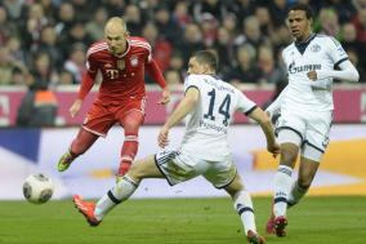 Pemain sayap Bayern Muenchen Arjen Robben (kiri) melepaskan tembakan yang membuahkan gol keempat (dari lima) timnya pada pertandingan Bundesliga melawan Schalke, di Allianz Arena, Sabtu (1/3/2014).