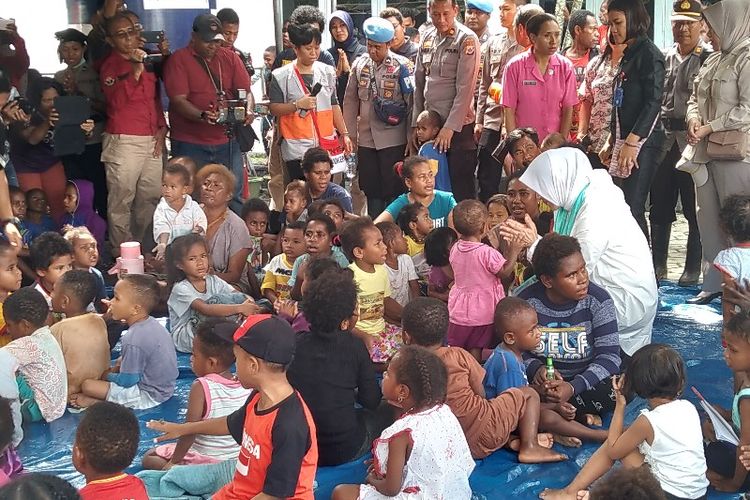 Istri Kapolri Tri Suswati Karnavian (baju putih) sedang bercenkrama dengan anak-anak pengungsi  yang ada di Posko Induk Sentani, Kabupaten Jayapura, Papua, Jumat (22/3/2019).