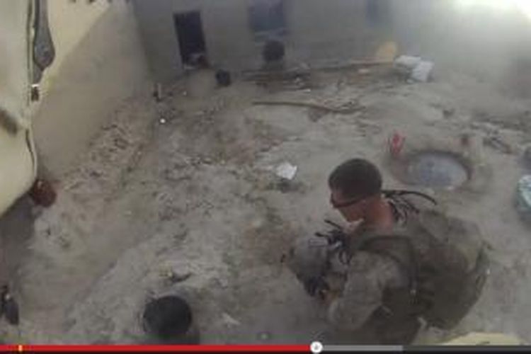 Seorang marinir AS memeriksa helmnya setelah terkena tembakan sniper di Afganistan