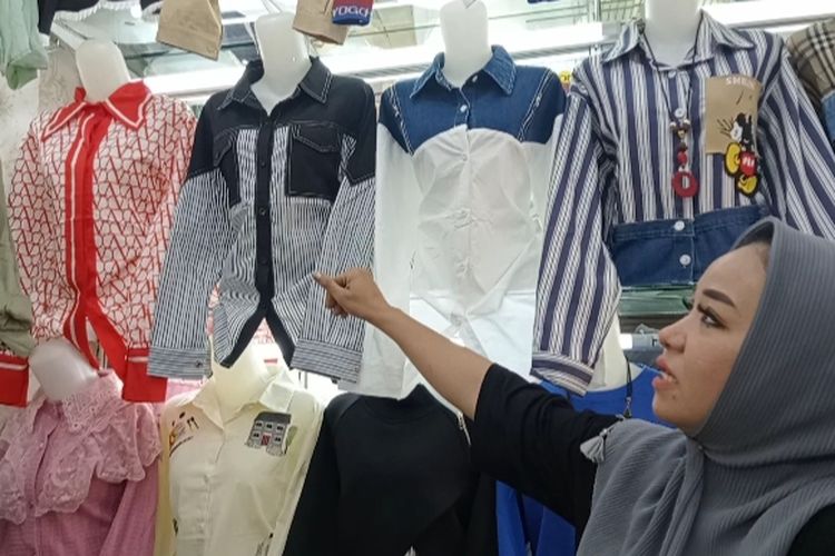 Seorang pedagang memperlihatkan beberapa model atasan fashion Bangkok yang banyak diminati pelanggan di butik New DC Collection, Khatulistiwa Plaza, Pontianak, Kalimantan Barat.