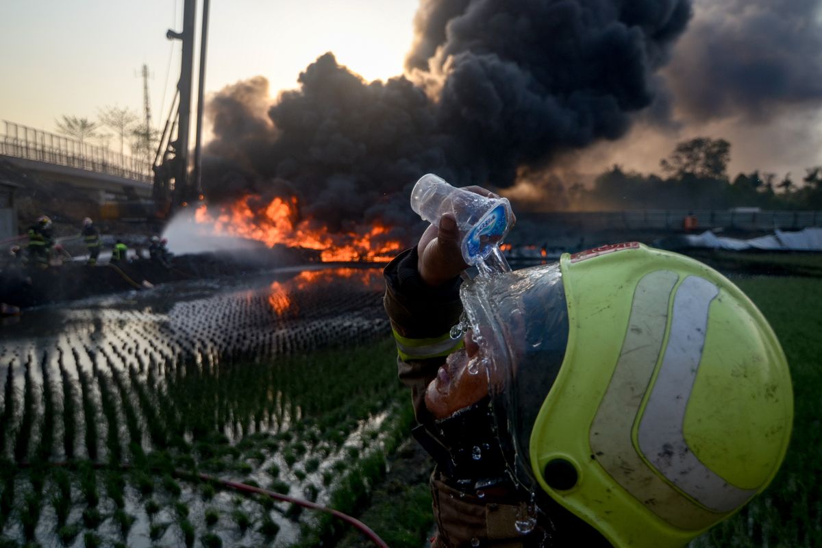 Seorang pemadam kebakaran membasuh mukanya saat berusaha memadamkan kebakaran pipa minyak milik PT Pertamina di Melong, Cimahi, Jawa Barat, Selasa (22/10/2019). PT Pertamina masih melakukan investigasi terkait kebakaran pipa milik pertamina itu yang letaknya berdekatan dengan proyek Kereta Cepat Indonesia China (KCIC) Jakarta-Bandung.