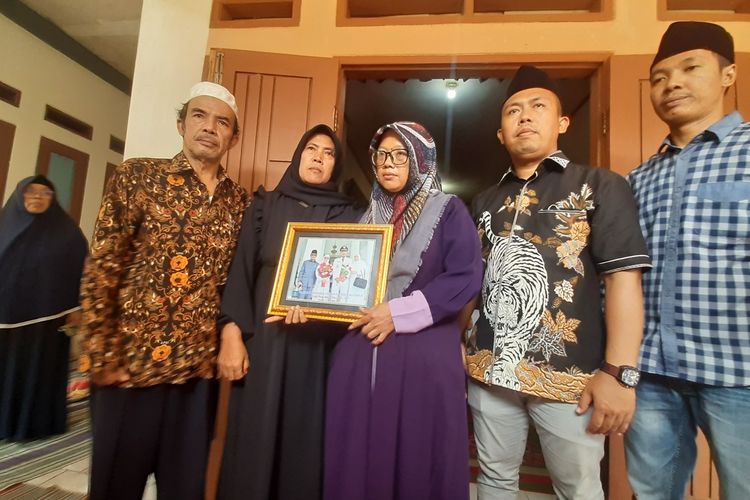 Kuasa hukum korban Eki Wijaya (kanan) bersama istri Kades Curuggoong Salamunasir (kanan kedua) memperlihatkan foto saat pelantikan menjadi Kades.