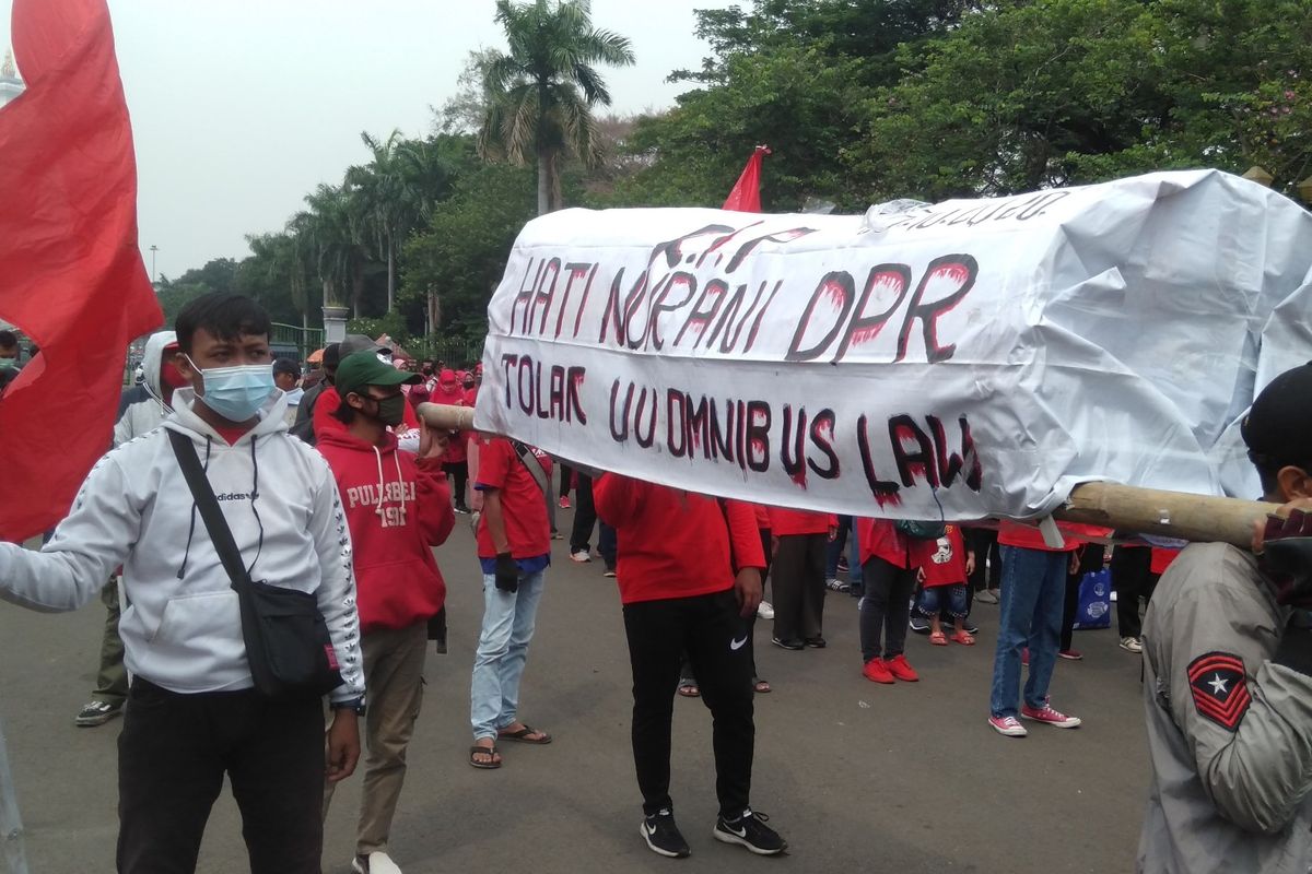 Masa membawa keranda saat gelar aksi tolak omnibus law Undang-Undang Cipta Kerja di kawasan Patung Kuda, Jakarta Pusat (16/10/2020)