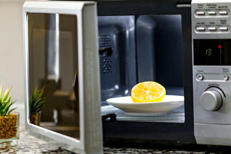 Ilustrasi membersihkan microwave dengan lemon. 