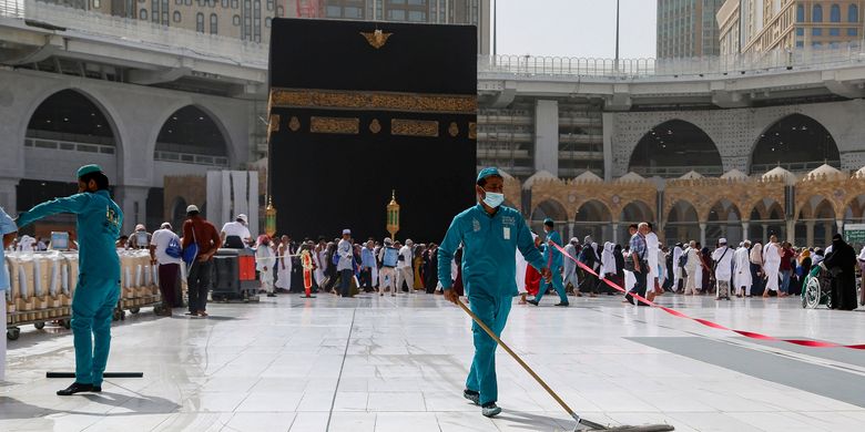 Petugas kebersihan dengan peralatan lengkap sedang membersihkan area Kakbah di Masjidil Haram, Mekah, Arab Saudi, Selasa (3/3/2020).(Ganoo Essa/REUTERS)