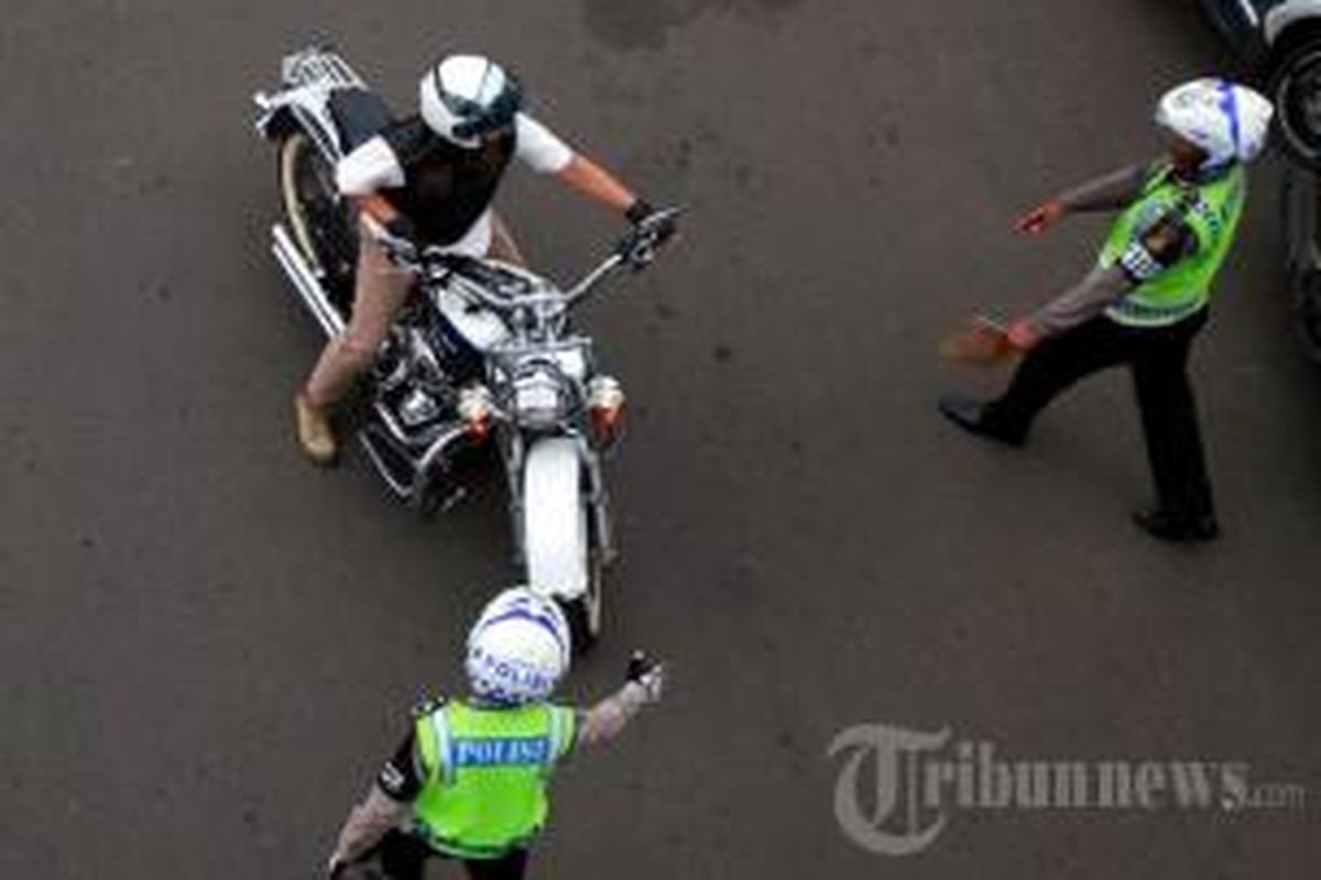 Pengendara sepeda motor Harley Davidson B 6168 ESG dihentikan Polisi untuk ditilang saat melintas di Jalan MH Thamrin, Jakarta Pusat, Minggu (18/1/2015). Polisi mulai menilang pengendara sepeda motor yang melintasi jalan protokol, yakni dari MH Thamrin sampai dengan Medan Merdeka Barat.