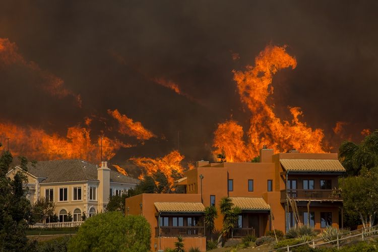 Kobaran api mendekati perumahan di kawasan Malibu, California, Jumat (9/11/2018). Warga Malibu, termasuk para selebritas, diperintahkan mengungsi karena api terus membesar. 