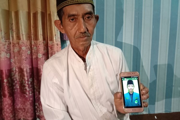 Mustain, ayah dari Imam Suhrowardi alias Ardi, menunjukkan foto anaknya yang meninggal saat menghadiri resepsi 1 abad NU di Sidoarjo, Selasa (7/2/2023).