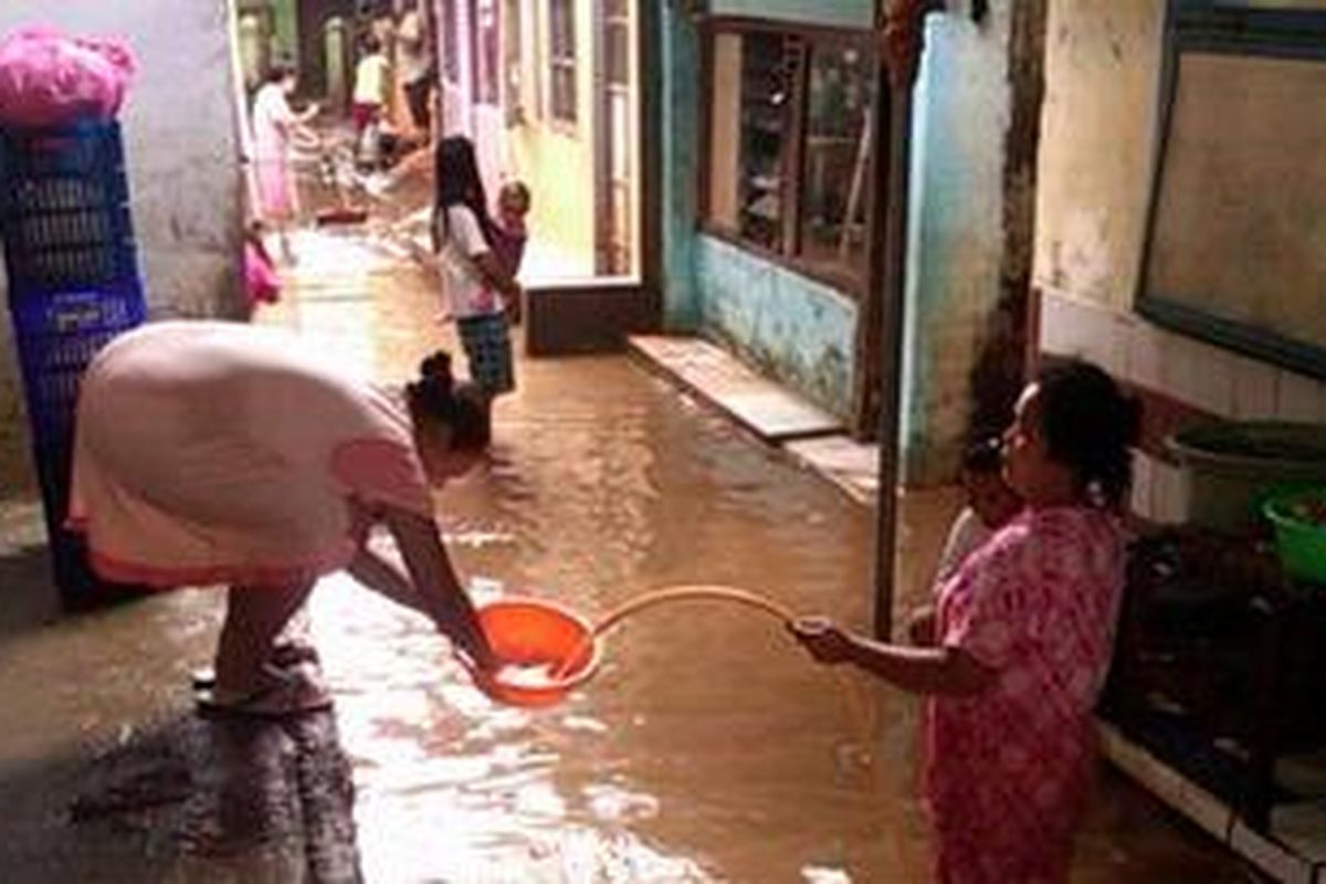 Seorang ibu tampak tengah memberikan baskom ke ibu lainnya. Aktifitas mereka adalah untuk menyambut upacara pernikahan yang akan berlangsung di Kampung Pulo, Jatinegara, Jakarta Timur.