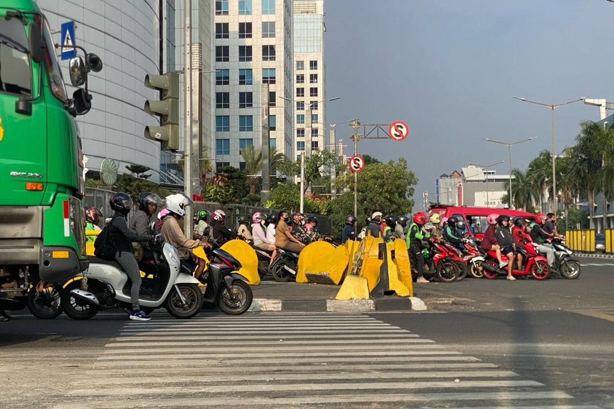 Para pengendara di Persimpangan Emporium Pluit, Penjaringan, Jakarta Utara, yang melewati marka jalan pembatas garis putih, Selasa (14/11/2023).