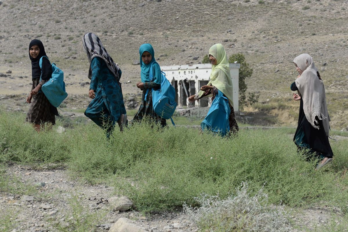 Foto yang dirilis pada 22 Juli 2019 memperlihatkan anak-anak sekolah di Afghanistan tengah pulang sekolah di SMP Papen yang hancur di distrik Deh Bala, Provinsi Nangarhar.