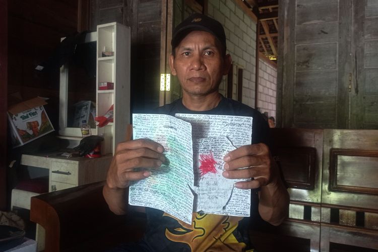 Rukijan Alex Sunandar memperlihatkan tulisan tangan istrinya yang ditemukan warga sat dilempar dari dalam rumah mertuanya. Selama 7 tahun Rukijan mengaku tidak bisa bertemu dengan anak dan kedua istrinya karena pintu rumah mertuanya tertutup rapat.