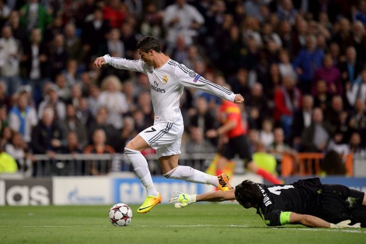 Bintang Real Madrid, Cristiano Ronaldo, mengelabui penjaga gawang Juventus, Gianluigi Buffon, pada partai fase grup Liga champions di Stadion Santiago Bernabeu, 23 Oktober 2013.