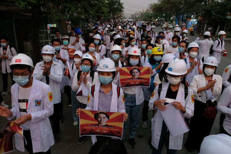 Medical staff and students take part in an early morning protest against the military coup and crackdown by security forces on demonstrations in Mandalay on March 21, 2021. (Photo by STR / AFP)