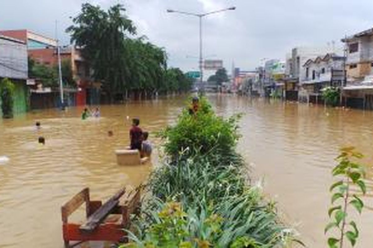 Dua ruas Jalan Otista Raya sebelum Terminal Kampung Melayu, Jakarta Timur, tergenang banjir setinggi 70-80 cm akibat luapan air Sungai Ciliwung, Rabu (22/1/2014).