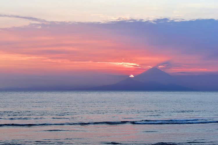 Ilustrasi pemandangan Gunung Agung dilihat dari Pantai Senggigi di Lombok, Nusa Tenggara Barat.