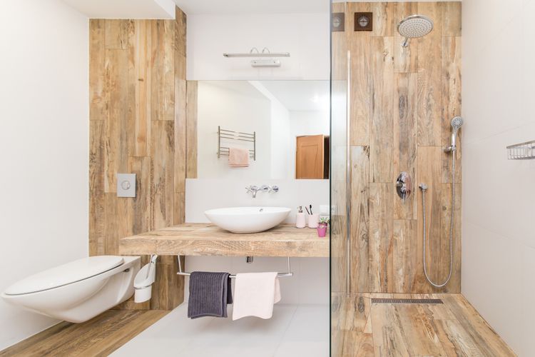 Area dinding dan lantai kamar mandi yang ditutupi oleh ubin keramik motif kayu