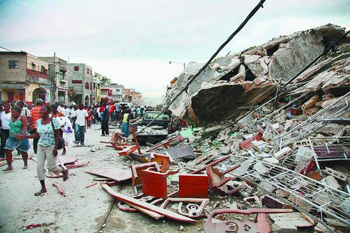 Warga Haiti berjalan melalui puing-puing dan bangunan yang diporak-porandakan gempa dahsyat berkekuatan 7,0 skala Richter, di Port-au-Prince, Haiti, Selasa sore atau Rabu (13/1) pagi WIB. Pusat gempa hanya sekitar 15 kilometer dari ibu kota Haiti, Port-au-Prince, sehingga tak heran jika kerusakan terlihat begitu parah. Ribuan orang diperkirakan masih tertimbun puing.