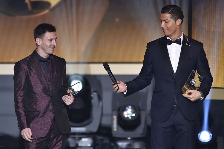 Pemain depan Real Madrid dan Portugal Cristiano Ronaldo memberikan microhpone ke Barcelona dan pemain depan Argentina Lionel Messi (kiri) ketika mereka berdiri di atas panggung setelah terpilih dalam FIFA FIFPro World XI 2014 selama upacara penghargaan FIFA Ballon dOr di Kongresshaus di Zurich pada 12 Januari